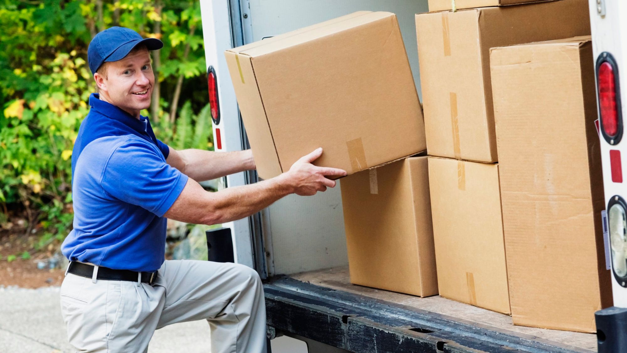 A movers company's employee moving cartons in a van